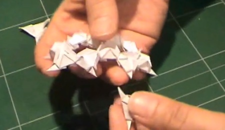 mãos manipulando o origami